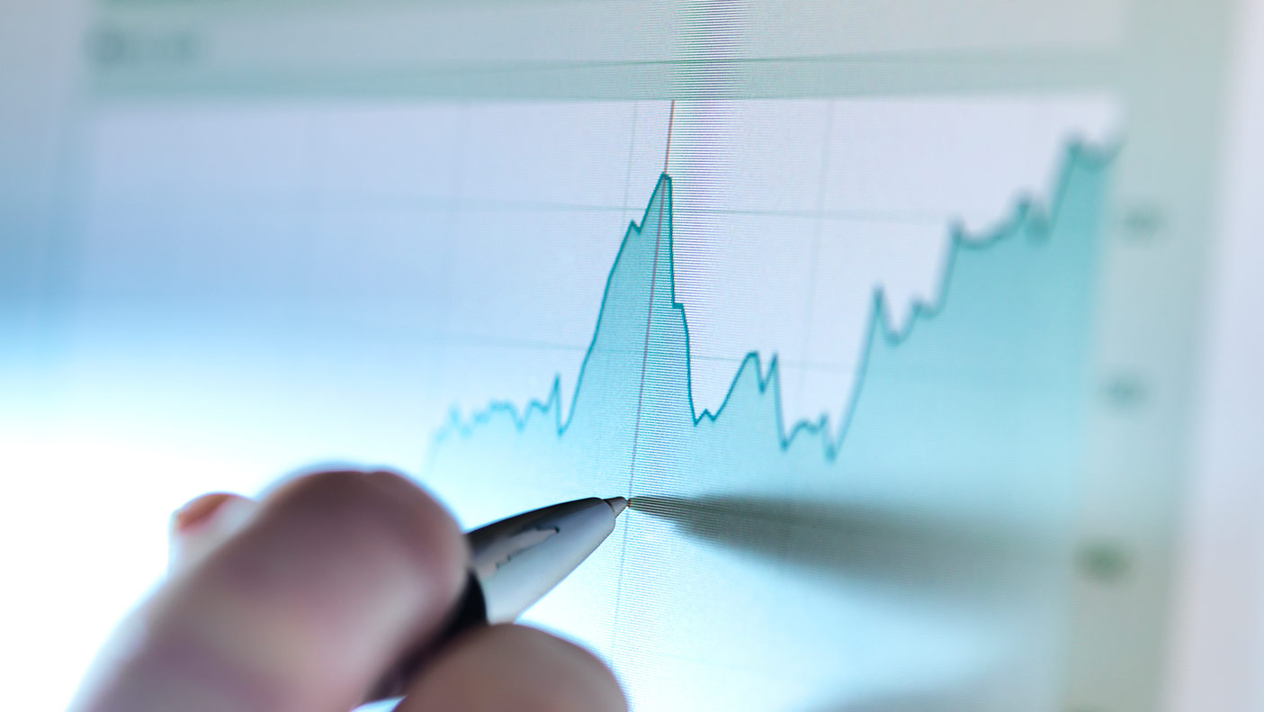 Hand of a accounatant analysing line graph on computer screen