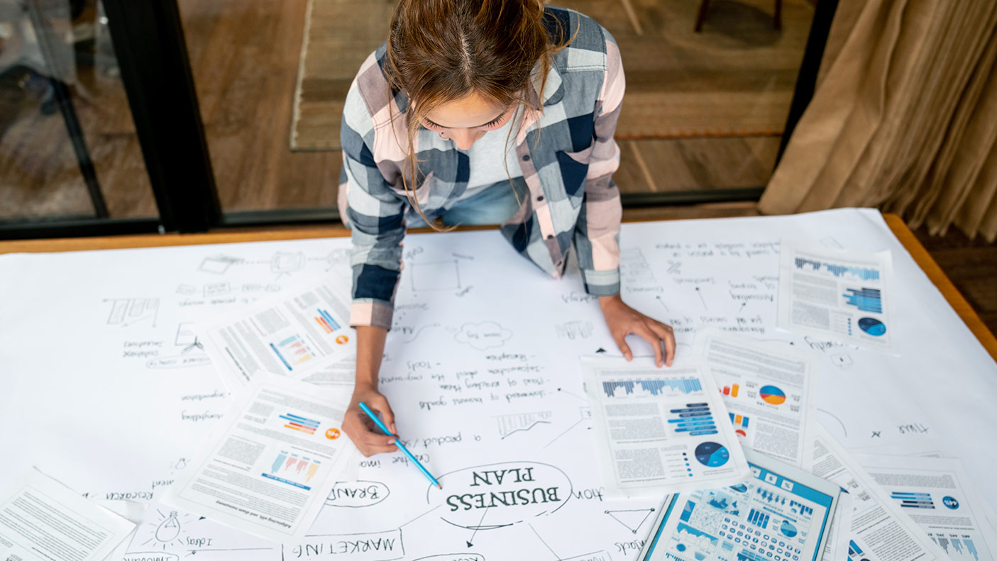 Stock image looking down at a woman looking at papers on a desk