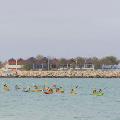 A group of participants padding on the ocean with Hillarys in the background