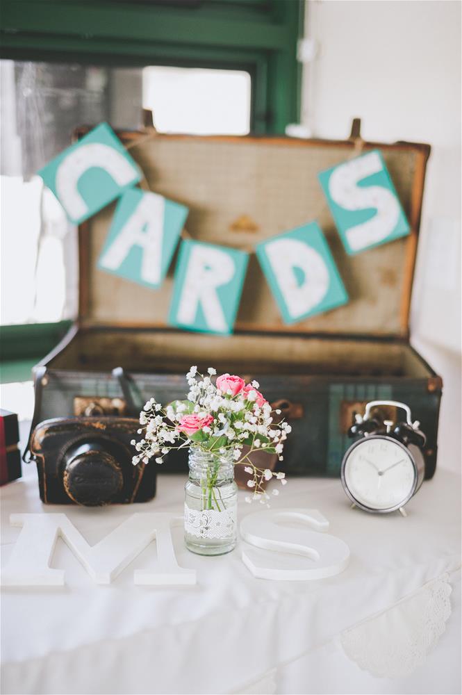 Wedding decorations including an old luggage case, camera, clock and flowers